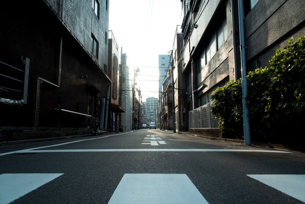 pexels photo 1626289 Quiet urban alley with zebra crossing, lined by buildings in soft morning light.